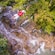A man rides a zip line over a waterfall and a jungle